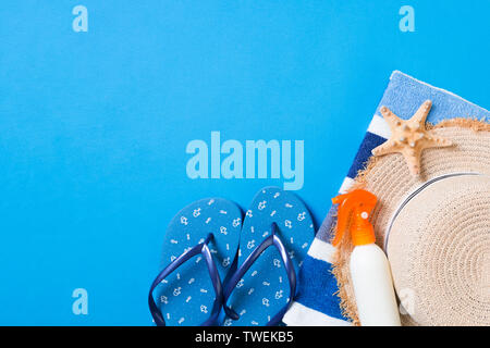 Été plage télévision jeter accessoires. Bouteille d'écran solaire crème, chapeau de paille, tongs, serviette et coquilles sur fond de couleur. Concept de vacances voyage wi Banque D'Images