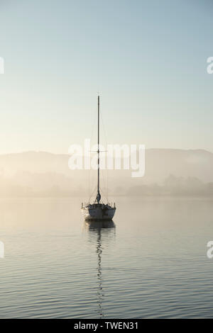 Belle image paysage unplugged de yacht à se reposer toujours dans le calme de l'eau dans le lac Lake District au cours de l'automne automne misty pacifique sunrise Banque D'Images