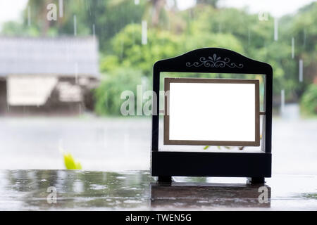 Cadre photo vide vintage design avec rainy sur table en bois Banque D'Images