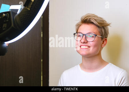 Heureux fille heureuse nouvelle coupe. master coupe de photographies sur votre smartphone à votre travail. Saint-petersbourg. La Russie. 06.20 2019 Banque D'Images