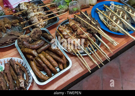 Au Laos, l'alimentation de rue, de mise au point sélectionnée Grill. Différents types de chair de poisson et d'autres aliments sur le compteur de la table. L'alimentation de rue en Asie. Banque D'Images