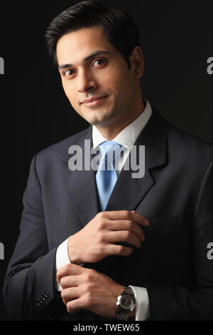 Businessman adjusting cuff links sur son costume Banque D'Images