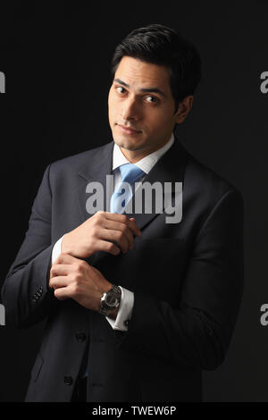 Businessman adjusting cuff links sur son costume Banque D'Images