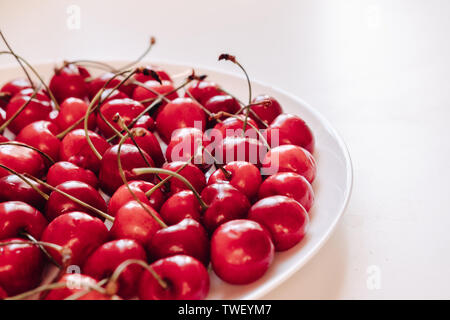 La plaque avec la cerise douce libre. L'été fraîchement récolté en berry white bowl. La vitamine contenant des fruits mûrs. Les matières de l'ingrédient alimentaire, régime végétarien. Bio, eco, l'agriculture biologique produire Banque D'Images
