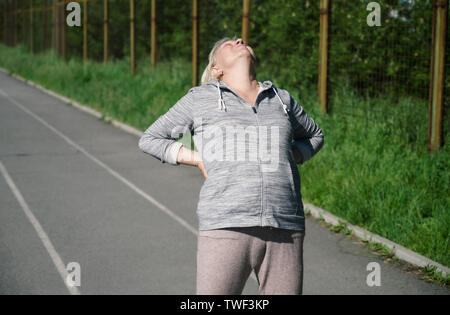 Femme âgée de faire les exercices en public du stade. Banque D'Images