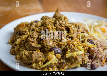 Nourriture jamaïcaine. Chèvre au curry jamaïcain servi avec riz et pois traditionnels Banque D'Images