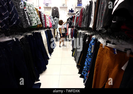 ANTIPOLO CITY, PHILIPPINES - le 18 juin 2019 : un client choisit d'une variété de vêtements sur l'affichage sur des étagères dans un magasin. Banque D'Images