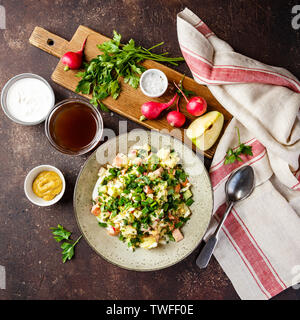 Soupe froide Okroshka russe avec des saucisses, des légumes et de kvas bol et ingrédients sur le tableau noir. Vue d'en haut. Banque D'Images