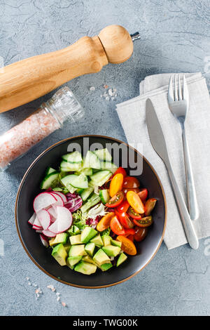 Bol bouddha vegan. Bol avec des légumes crus - tomates cerises, concombre, radis, avocat, laitue Romano, Frisse et ridicho. Végétarien sain Banque D'Images