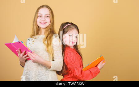 Des cahiers d'écriture. Retour à l'école. L'amitié sisterhood. petite filles avec note books. Les élèves de lire un livre. Projet d'école. Heureux petits enfants prêts pour la leçon. Concentrés sur l'étude. Banque D'Images