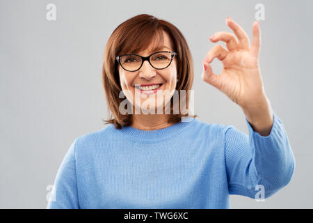 Happy senior woman in glasses montrant ok part sign Banque D'Images