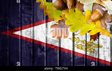 American Samoa drapeau sur fond de bois de l'automne avec des feuilles et de la bonne place pour votre texte. Banque D'Images