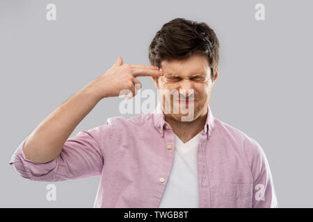 Man making headshot par doigt geste des armes à feu Banque D'Images