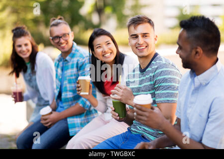 Les amis de boire du café et du jus de parler en ville Banque D'Images