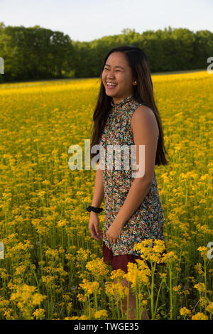 Une belle adolescente rit tandis que dans un champ de jaune à Fort Wayne, Indiana, USA. Banque D'Images