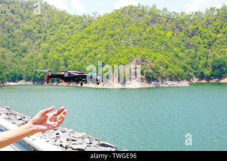 Drone avec l'appareil photo professionnel prend des photos du réservoir dans les montagnes Banque D'Images