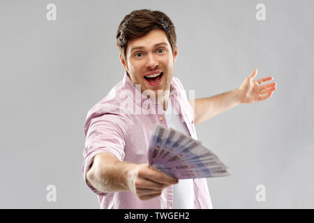 Heureux jeune homme avec le ventilateur de l'argent euro Banque D'Images