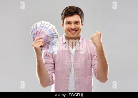 Heureux jeune homme avec le ventilateur de l'argent euro Banque D'Images