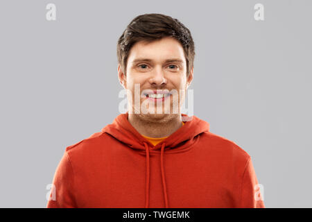 Smiling young man in red sweat gris plus Banque D'Images