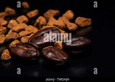 Les grains de café et le café instantané granules sur un fond sombre, macro, close-up Banque D'Images