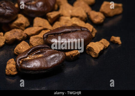 Les grains de café et le café instantané granules sur un fond sombre, macro, close-up Banque D'Images