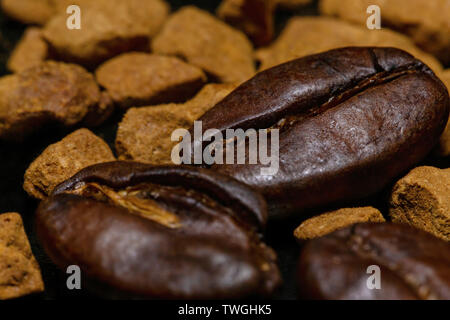 Les grains de café et le café instantané granules sur un fond sombre, macro, close-up Banque D'Images