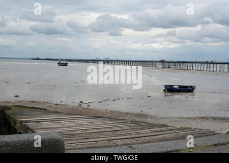 Southend-on-sea-2019-05-28, bateau de pêche amarré sur le sable avec l'embarcadère de l'arrière-plan Banque D'Images