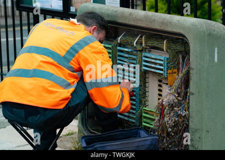 Ingénieur de la BT Openreach travailler avec câblage en boîte de jonction street Banque D'Images