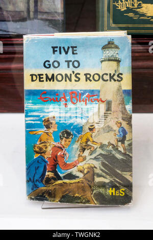 Une copie de cinq rendez-vous pour les roches du démon par Enid Blyton en vente dans une librairie fenêtre. L'une de ses célèbres cinq série de livres pour enfants. Banque D'Images