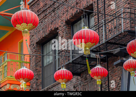Le rouge et or lanternes chinoises en face d'un vieux bâtiment en brique à San Francisco, Californie, USA. Banque D'Images