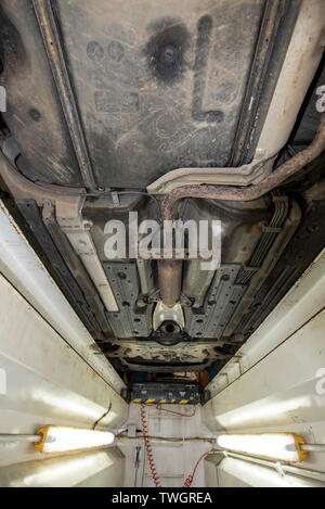 Toyota Prius, vol de catalyseur. Voir sous le véhicule d'une fosse d'inspection mécanique, indiquant l'emplacement des composants manquants ou endommagés. Banque D'Images