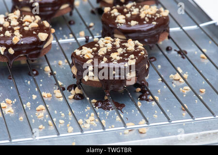 Beurre de cacahuètes enrobées de chocolat fait maison bicuits sablés. Round biscuits sablés au chocolat avec crème au beurre d'arachide au milieu Banque D'Images