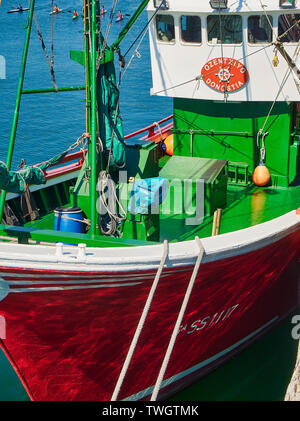 Un bateau de pêche amarré dans le port de Muelle del Hospitalillo Trintxerpe, avec quelques enfants kayak dans l'arrière-plan. Pasaia, Gipuzkoa, Espagne. Banque D'Images