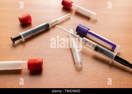 Caillot de sang ordinaire et activateurs de la seringue sur la table en bois en laboratoire, texturée de l'Inde. Banque D'Images