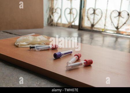 Caillot de sang ordinaire et activateurs de la seringue sur la table en bois en texture laboratoire. Banque D'Images