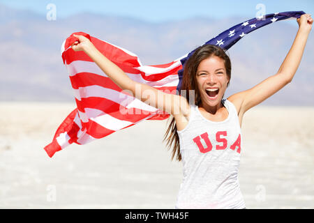 Drapeau américain - USA femme athlète sport gagnant cheering agitant drapeau américain Stars and Stripes plein air course dans la nature. Belle jeune fille heureuse d'encouragement multiculturelle joyeux et excité. Banque D'Images