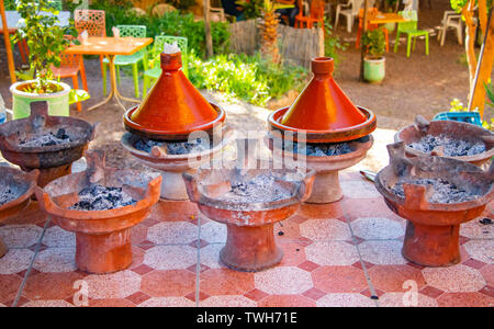 La cuisson des plats traditionnels marocains tajin. C'est la viande et quelques vegatebles ou fruits. Cette nourriture typique est cuite dans des contenants en céramique africaine. Banque D'Images