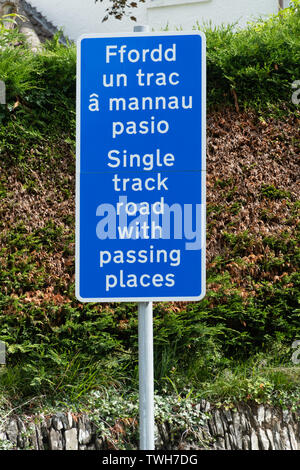 Panneau routier en gallois et en anglais - route à voie unique avec des lieux de passage (ONU Ffordd trac une mannau pasio), pays de Galles, Royaume-Uni Banque D'Images