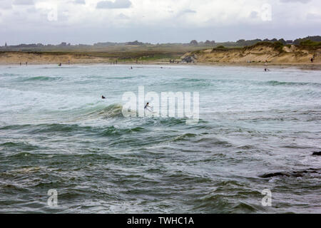 Côte de Bretagne avec de fortes vagues et surfer une vague Banque D'Images