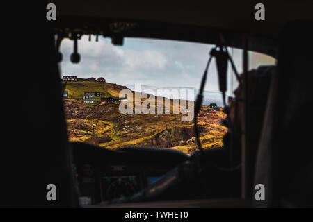 Vue aérienne de la ville Torshavn prises depuis l'intérieur d'un hélicoptère pendant un vol au dessus des îles Féroé avec pilote en photo (îles Féroé) Banque D'Images