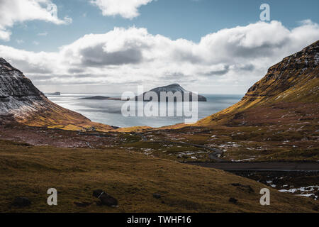 Vue sur l'île recouverte de neige Koltur, vu de l'serpentines vers le village des îles Féroé Nordradalur au printemps (îles Féroé, Danemark) Banque D'Images