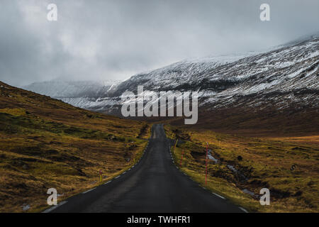 Vues road trip sur les routes sans fin sur les îles Féroé avec des pics de montagne couverte de neige, ciel bleu et nuages bas au printemps (îles Féroé) Banque D'Images