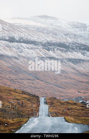 Vues road trip sur les routes sans fin sur les îles Féroé avec des pics de montagne couverte de neige, ciel bleu et nuages bas au printemps (îles Féroé) Banque D'Images