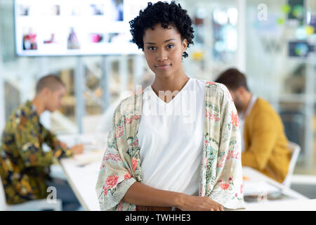 Designer de mode féminine s'appuyant sur une table dans la salle de conférence in office Banque D'Images