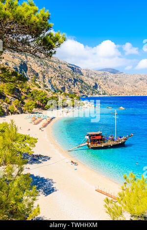 Bateau de tourisme à ancrage Apella belle plage sur l'île de Karpathos, Grèce Banque D'Images