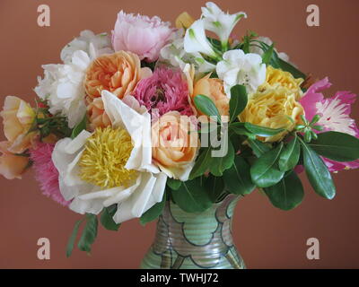 Un vase pour la chambre des blowsy, fleurs d'un jardin anglais au début de l'été : des roses, pivoines, pavots d'ornement et alstromeria Banque D'Images