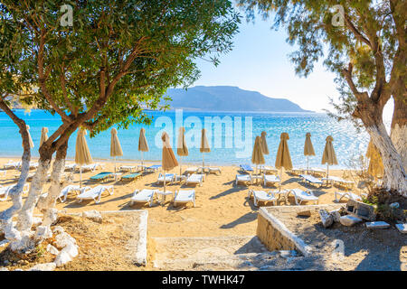 Entrée de Ammopi plage avec parasols et chaises longues sur l'île de Karpathos, Grèce Banque D'Images