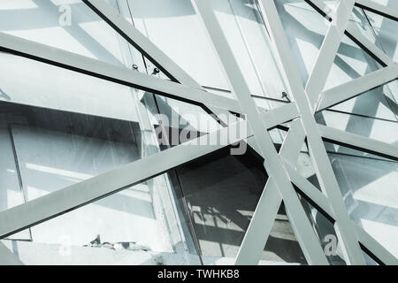 Résumé L'architecture commerciale, l'arrière-plan la façade de l'immeuble de bureau avec structure en acier et motif géométrique des panneaux de verre. Chat dort sur le mur. Blue Banque D'Images