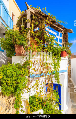 Maison avec vigne croissant drapeau grec sur façade dans Rhodes, l'île de Karpathos, Grèce Banque D'Images