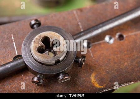 Filetage manuel en métal. Accessoires de serrurerie pour les petits travaux dans l'atelier de maison. Fond sombre. Banque D'Images